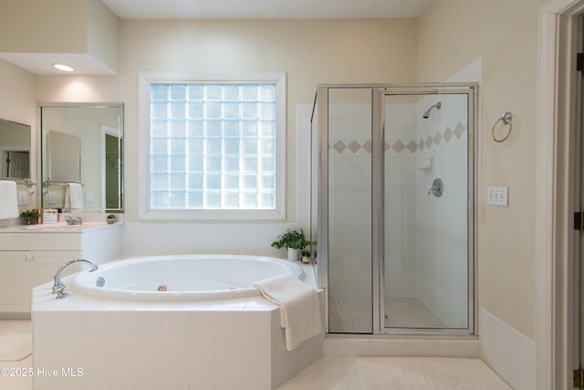 bathroom with tile patterned floors, vanity, and shower with separate bathtub