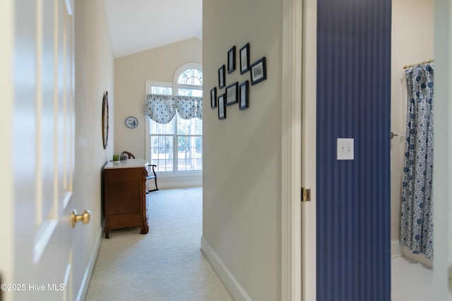 hall with lofted ceiling, light carpet, and a wealth of natural light