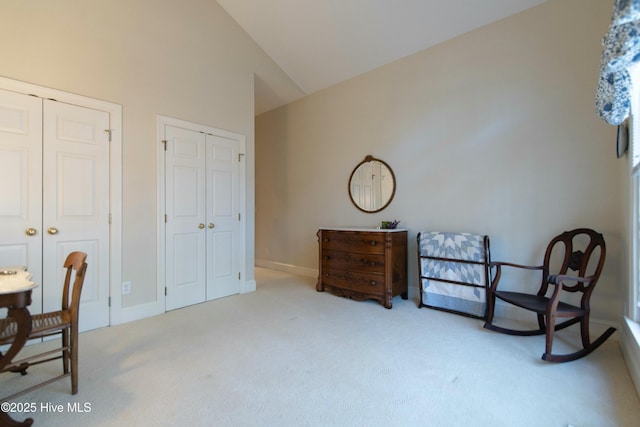 sitting room featuring light colored carpet and vaulted ceiling