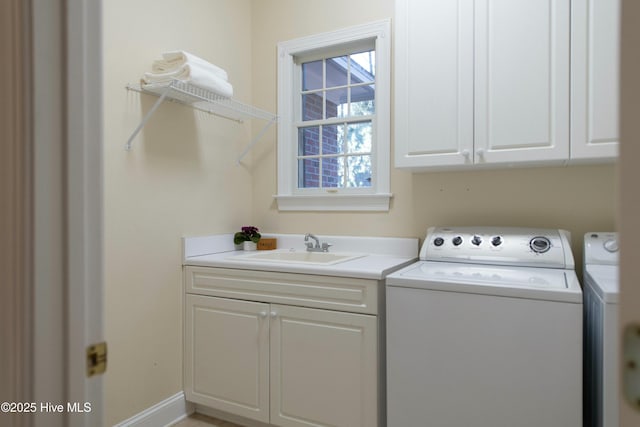 washroom featuring separate washer and dryer, sink, and cabinets