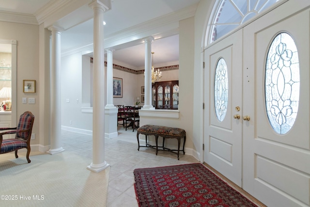 entryway with light tile patterned flooring, crown molding, and a chandelier