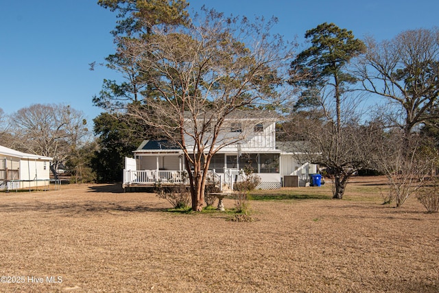 back of house with a yard and a sunroom