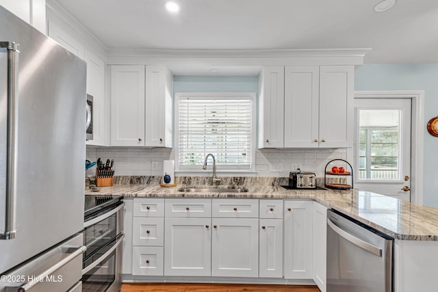 kitchen with sink, white cabinetry, and stainless steel appliances