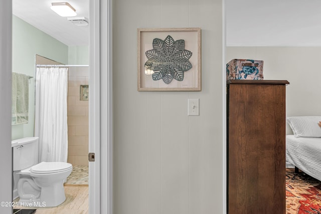 bathroom with curtained shower and toilet