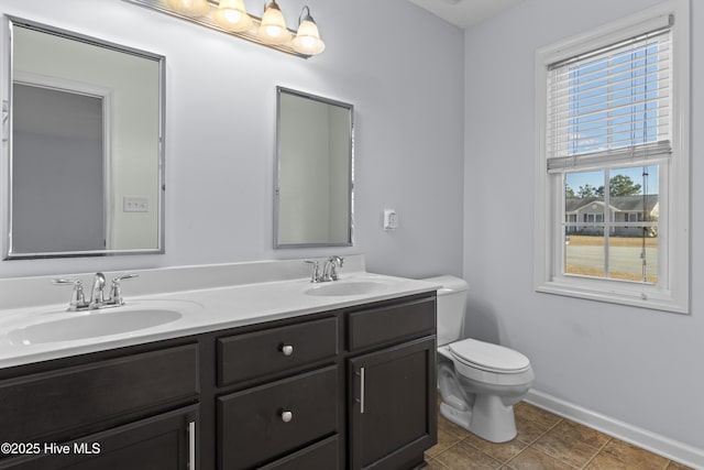 bathroom featuring toilet, vanity, tile patterned flooring, and plenty of natural light