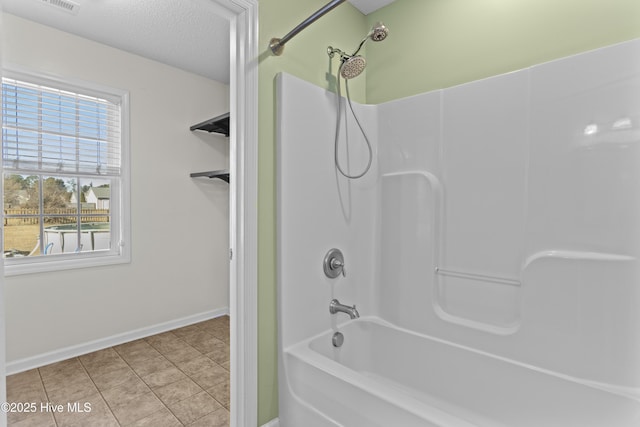 bathroom featuring shower / bathtub combination, a textured ceiling, and tile patterned flooring