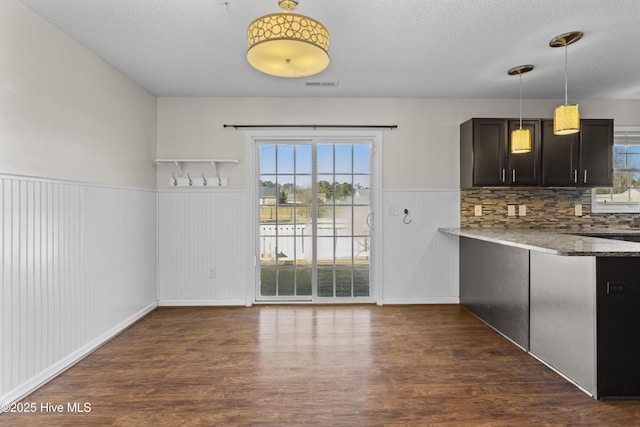 kitchen featuring decorative light fixtures, dark hardwood / wood-style floors, stone countertops, and dark brown cabinets