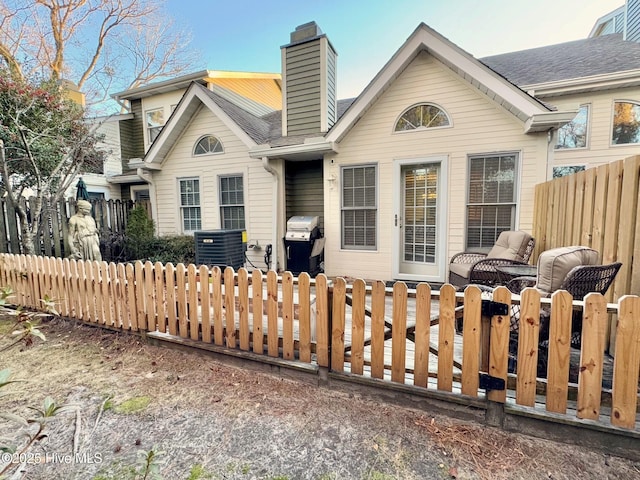 view of front of house with central AC unit and a fire pit