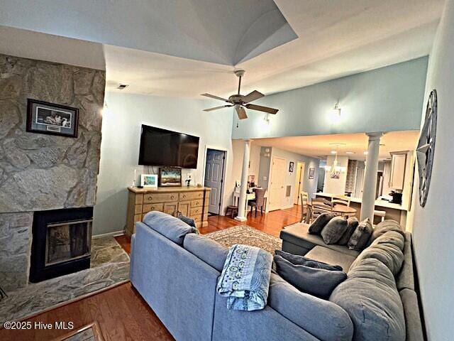 living room with vaulted ceiling, ceiling fan, a fireplace, and hardwood / wood-style floors