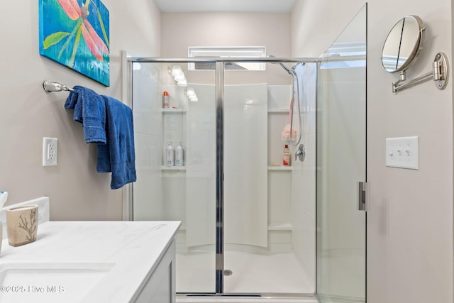 bathroom with a shower with door and vanity