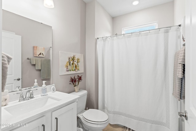 bathroom featuring a shower with shower curtain, vanity, and toilet