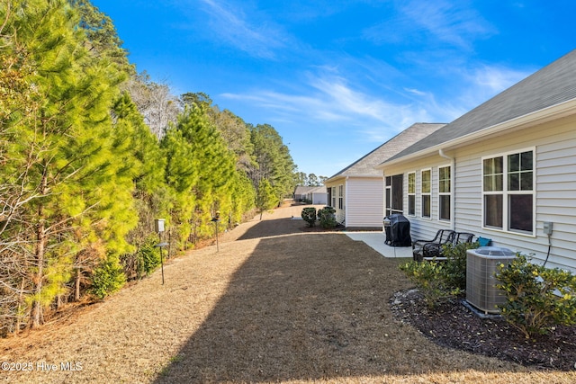 view of yard featuring central AC and a patio area