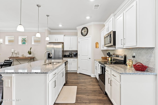 kitchen with appliances with stainless steel finishes, hanging light fixtures, decorative backsplash, white cabinets, and sink