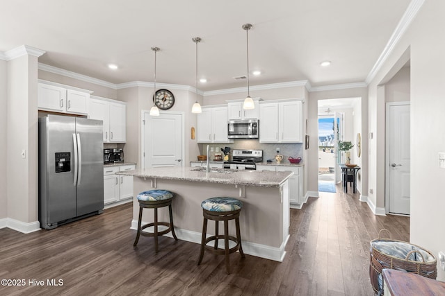 kitchen featuring white cabinets, stainless steel appliances, a center island with sink, and pendant lighting