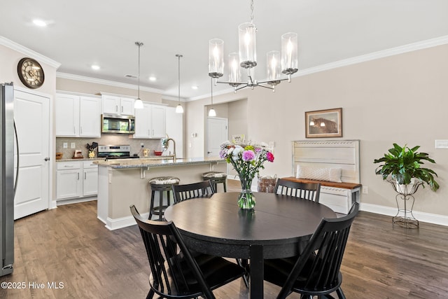 dining room with an inviting chandelier, ornamental molding, and dark hardwood / wood-style floors