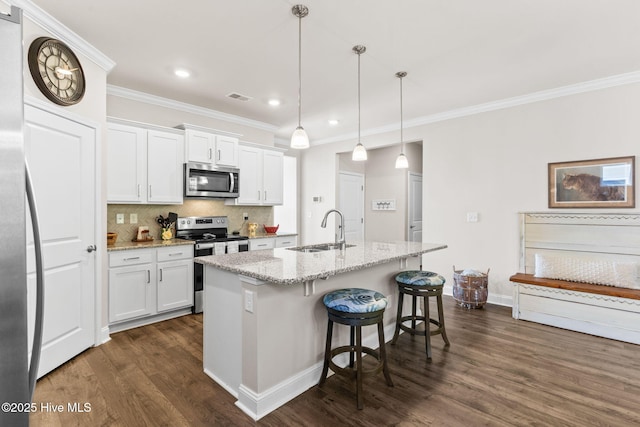 kitchen featuring appliances with stainless steel finishes, white cabinetry, a center island with sink, and sink