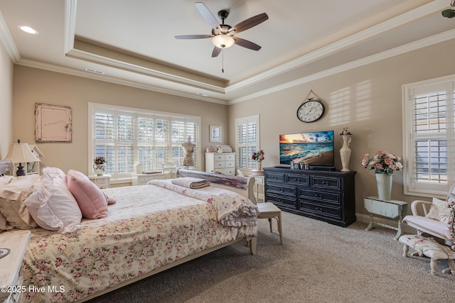 bedroom with crown molding, ceiling fan, carpet flooring, and a raised ceiling