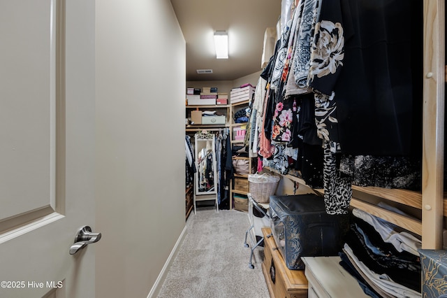 walk in closet featuring light carpet