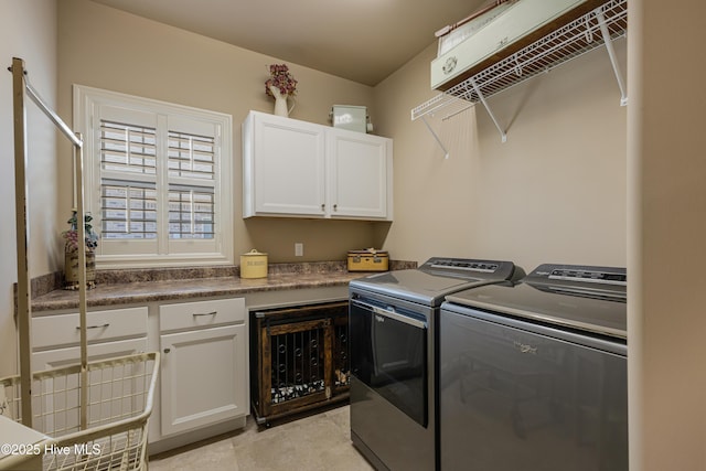 laundry area featuring cabinets, light tile patterned floors, and independent washer and dryer