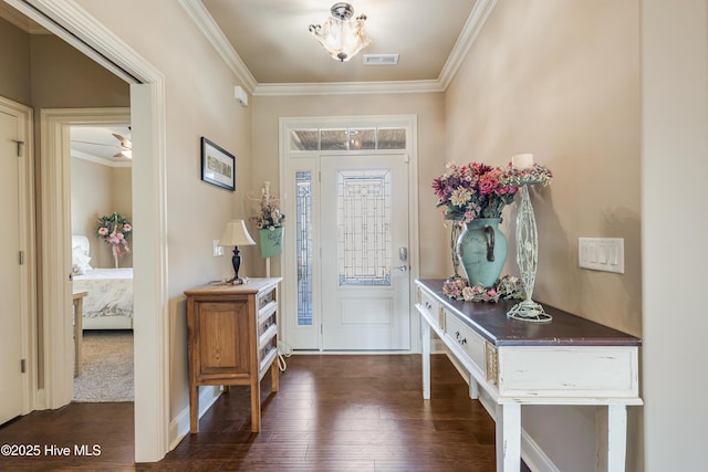 foyer entrance featuring ornamental molding and dark wood-type flooring