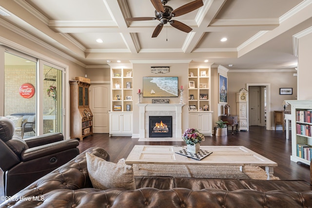 living room featuring crown molding, dark wood-type flooring, beam ceiling, coffered ceiling, and a tiled fireplace