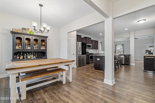 dining space featuring dark hardwood / wood-style flooring and an inviting chandelier