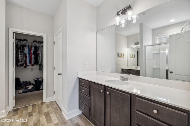 bathroom featuring hardwood / wood-style flooring, an enclosed shower, and vanity