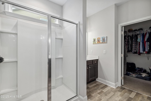 bathroom with hardwood / wood-style floors, an enclosed shower, and vanity