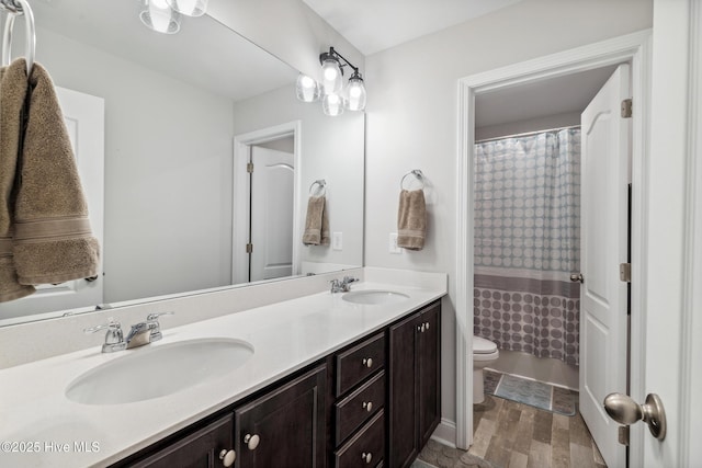 bathroom with walk in shower, hardwood / wood-style floors, vanity, and toilet