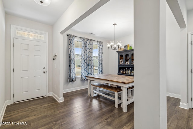 foyer entrance with a chandelier and dark hardwood / wood-style floors