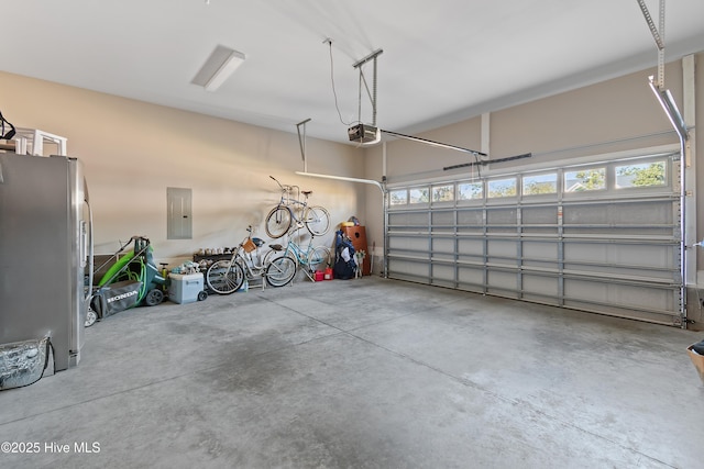 garage featuring stainless steel refrigerator, a garage door opener, and electric panel