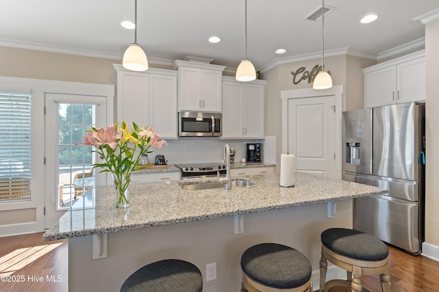 kitchen with stainless steel appliances, white cabinets, and pendant lighting