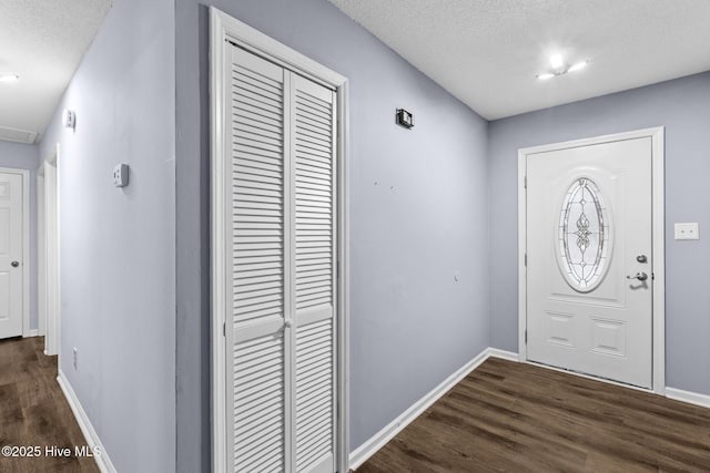 entrance foyer with dark hardwood / wood-style floors and a textured ceiling