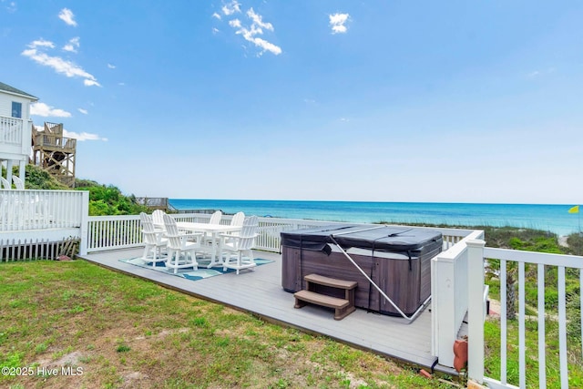 exterior space featuring a deck with water view and a hot tub