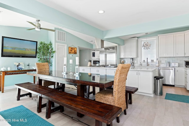 dining area with ceiling fan and vaulted ceiling