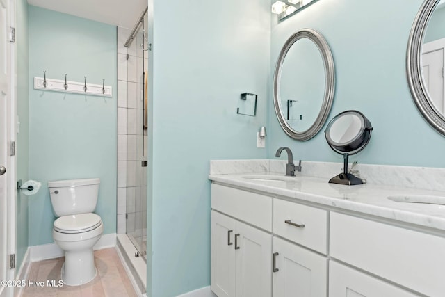 bathroom featuring tile patterned floors, vanity, toilet, and a shower with shower door