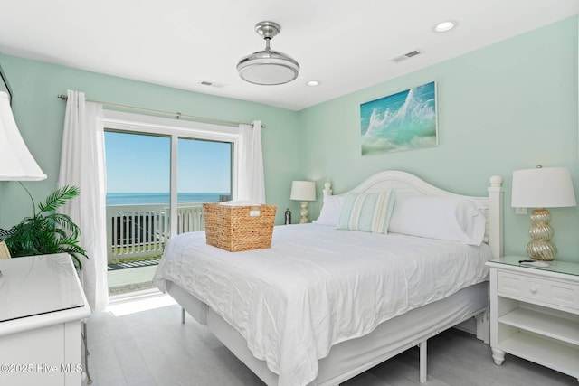 bedroom with access to exterior and a water view