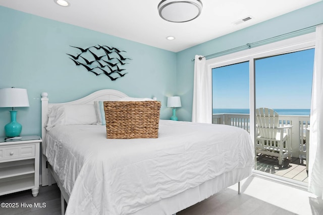 bedroom featuring access to exterior and a water view