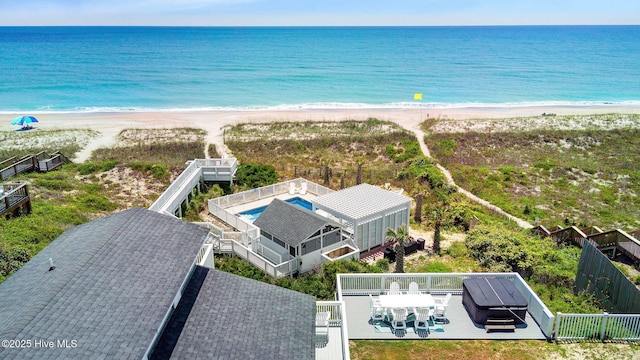 aerial view with a water view and a beach view