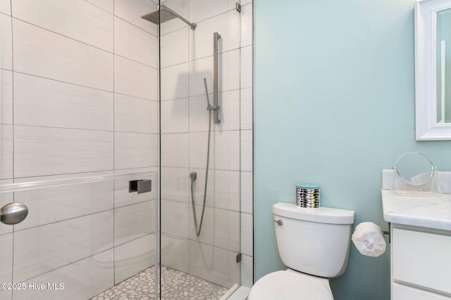 bathroom featuring vanity, toilet, and a shower with door