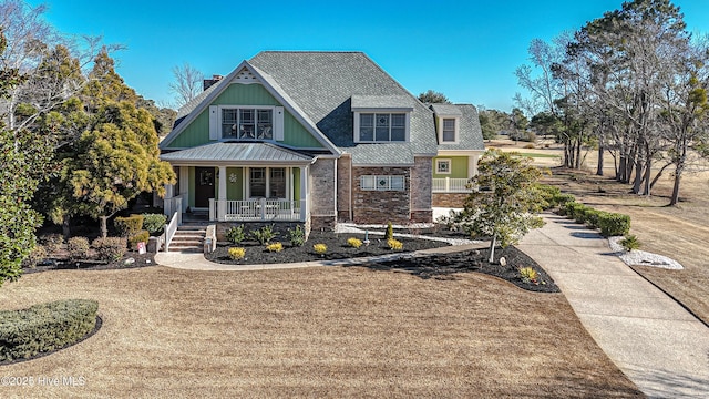 view of front of property with covered porch and a front yard