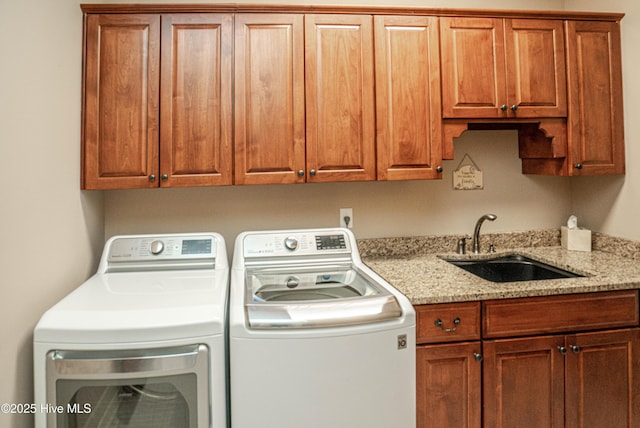 clothes washing area with sink, separate washer and dryer, and cabinets