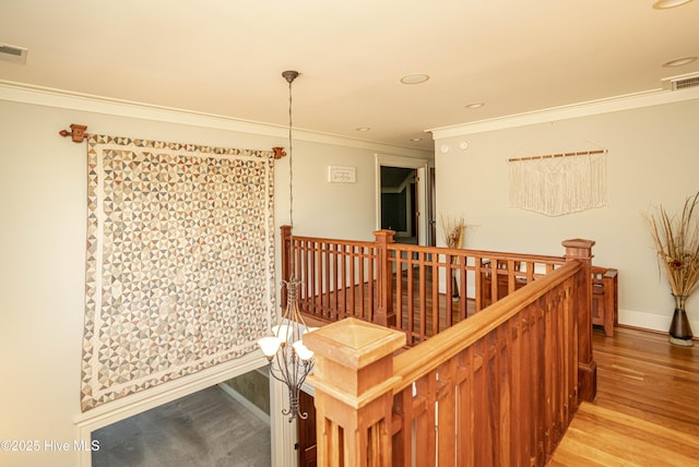 hall with ornamental molding and light hardwood / wood-style floors