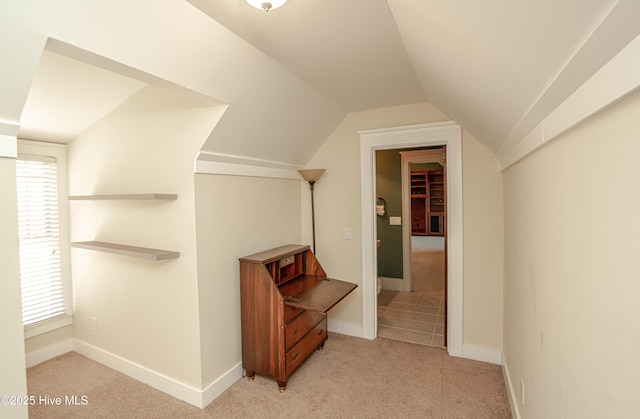 interior space featuring a healthy amount of sunlight, vaulted ceiling, and light colored carpet