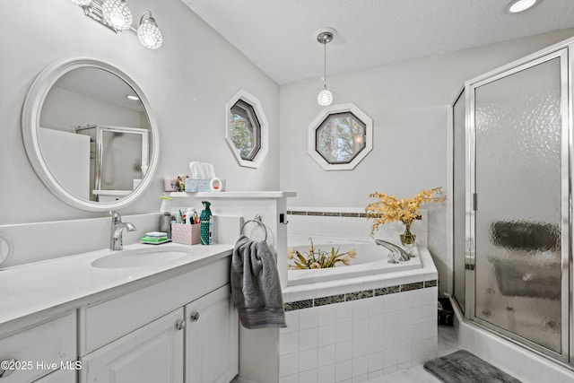 bathroom featuring vanity, a textured ceiling, and shower with separate bathtub