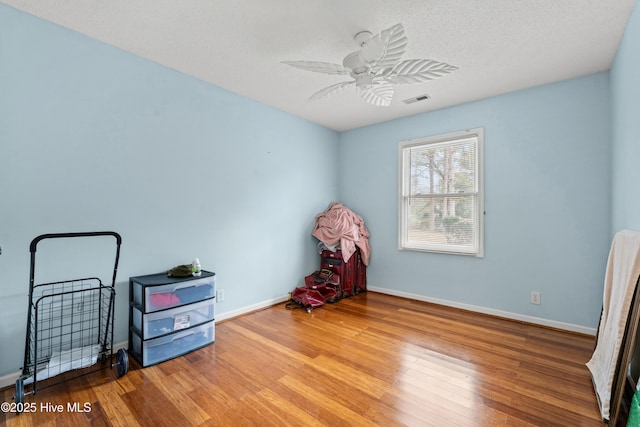 misc room featuring hardwood / wood-style flooring, a textured ceiling, and ceiling fan