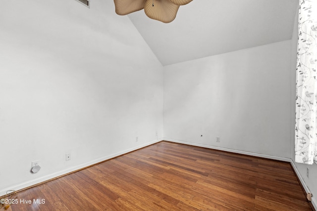 unfurnished room featuring dark wood-type flooring and lofted ceiling