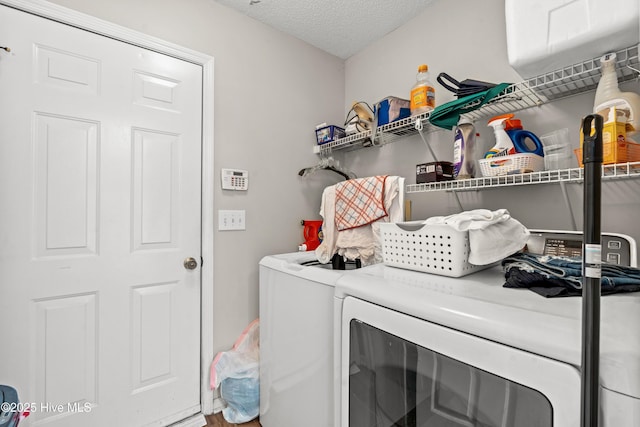 clothes washing area featuring a textured ceiling and independent washer and dryer