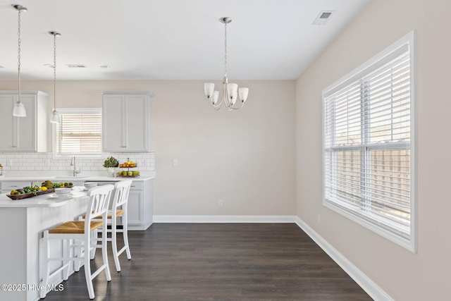 dining room with dark hardwood / wood-style flooring and an inviting chandelier