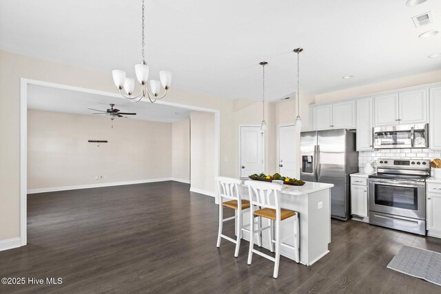 kitchen featuring appliances with stainless steel finishes, a center island, pendant lighting, and white cabinets